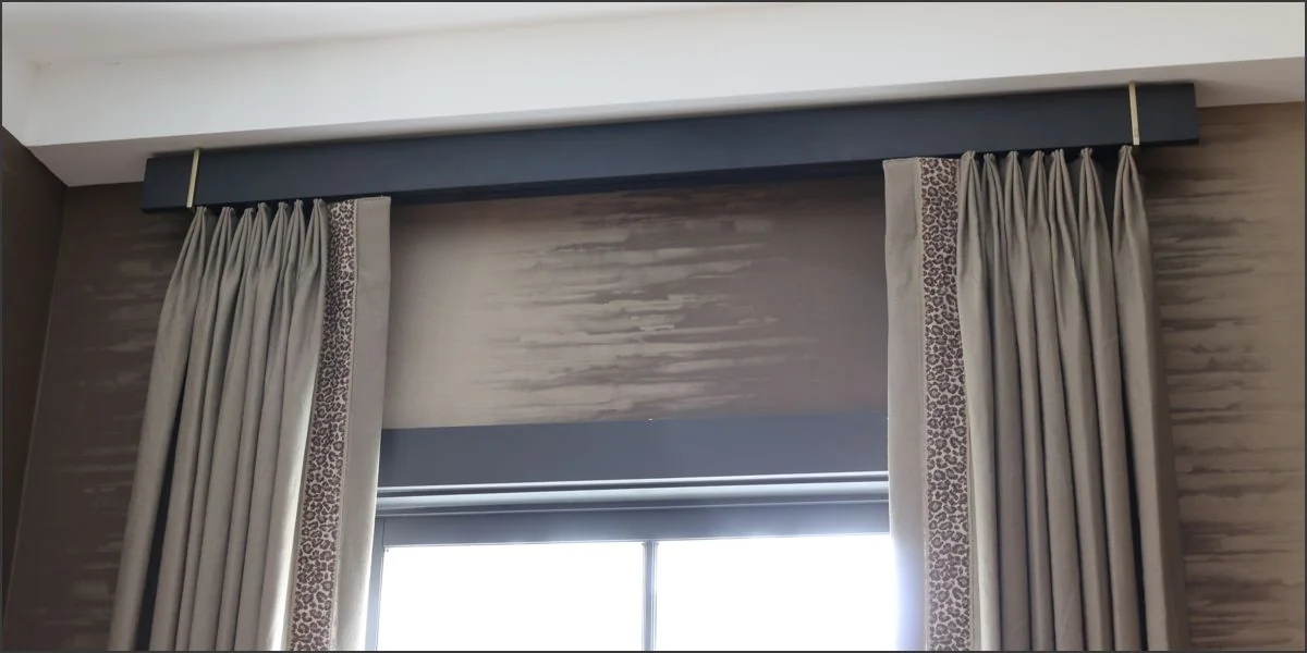Traverse rod concealed behind an architectural fascia